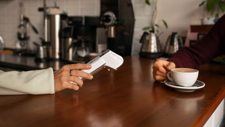 Small business owner accepting contactless card payment on A50 PRO card machine in UK shop
