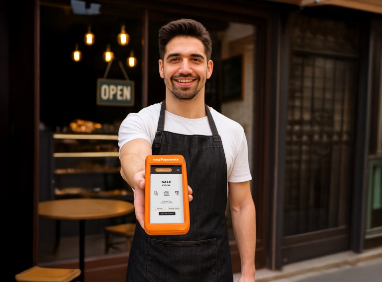 Barista demonstrating a PAX A920 PRO card machine outside a Dublin coffee shop