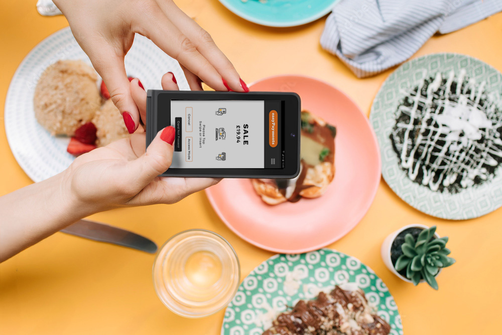 Waiter holding an easyGo portable card machine by easyPayments
