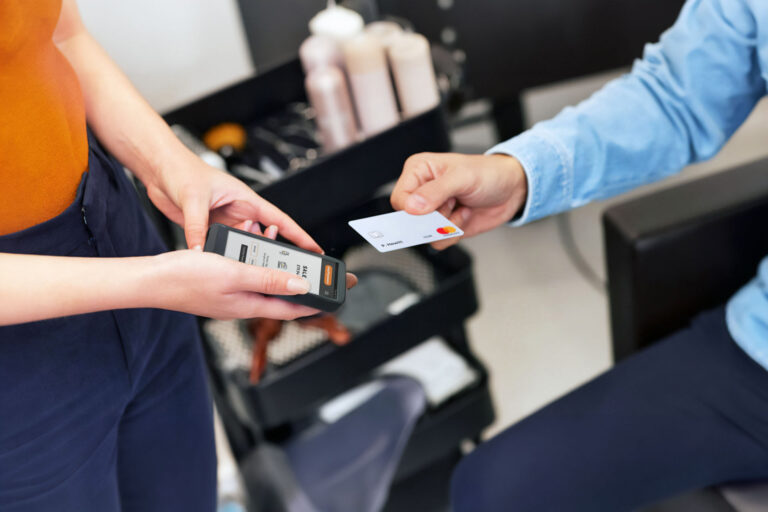 Mobile hairdresser taking card payment with easyGo mobile card reader after styling appointment