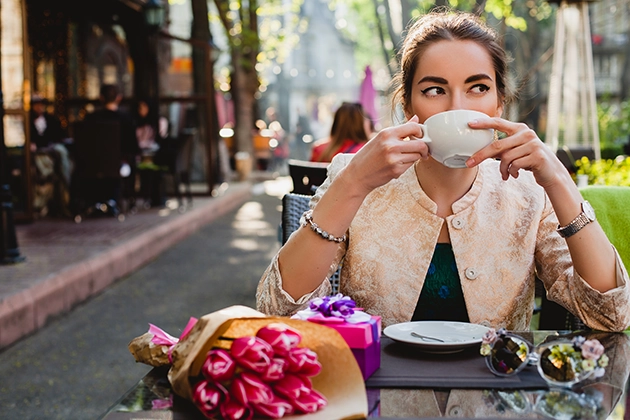 Person enjoying a coffee outside an Irish coffee shop in spring representing seasonal business growth